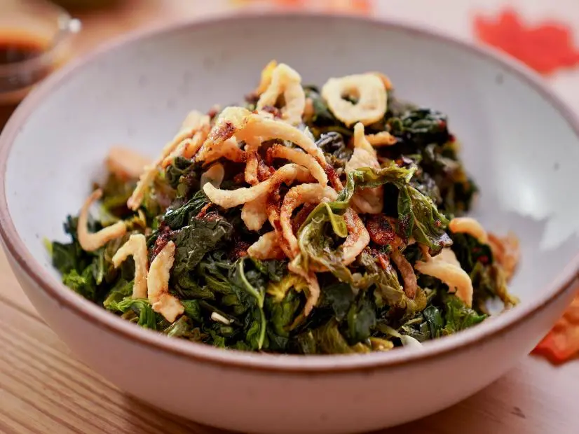 Beauty shot of Molly Yeh's Greens with Crispy Onions and Chili Crisp as seen on Girl Meets Farm, Season 11.