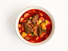 Traditional hungarian goulash soup (beef stew, potato, celery, parsley, carror, cummin, red pepper spice) on white background