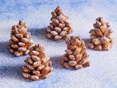 With their crunchy cereal exteriors and creamy peanut-butter-and-chocolate-hazelnut centers, these wintery pinecones are a delicious and easy way to serve your guests adorable holiday treats — without turning on your oven.