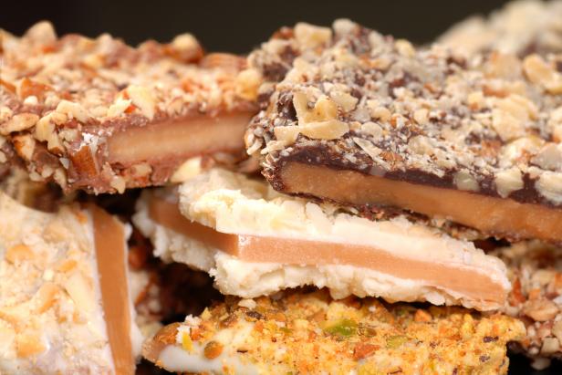 Different types of English Toffee with a variety of chocolates and nuts with a shallow depth of field.