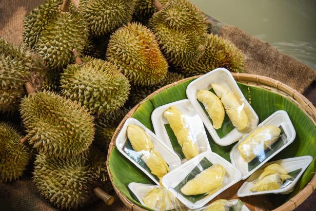 Fresh durian peeled on tray and ripe durian tropical fruit for sale in the market