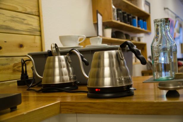 A side-view of kettles at a coffee shop.