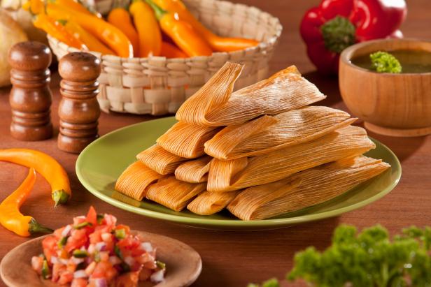 Traditional Tamales served with avocado and pico de gallo on mexican decoration