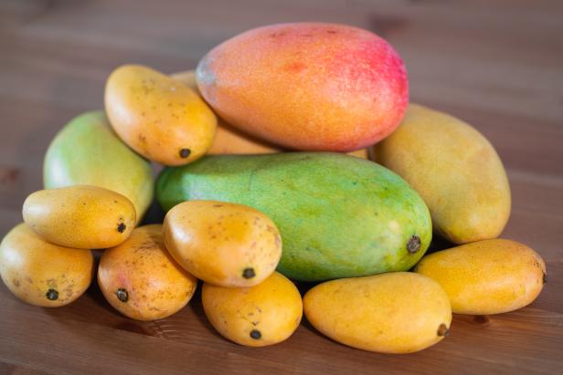 Stack of several varieties of Mangoes of different size and colors