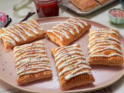 Beauty shot of Molly Yeh's Strawberry Vanilla Bean Pastry Pockets with Cream Cheese Glaze, as seen on Girl Meets Farm, Season 13.