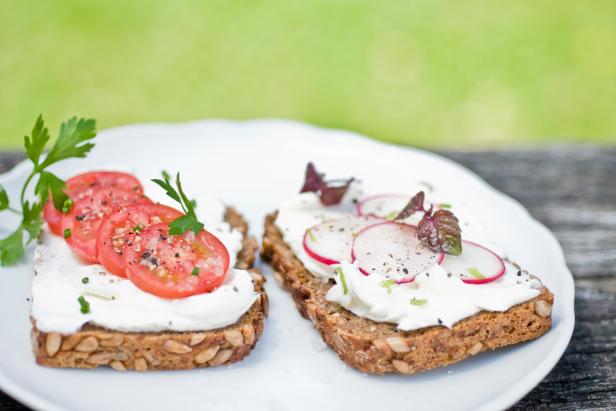 Two slices of whole-grain bread with curd cheese tomatoes and radish