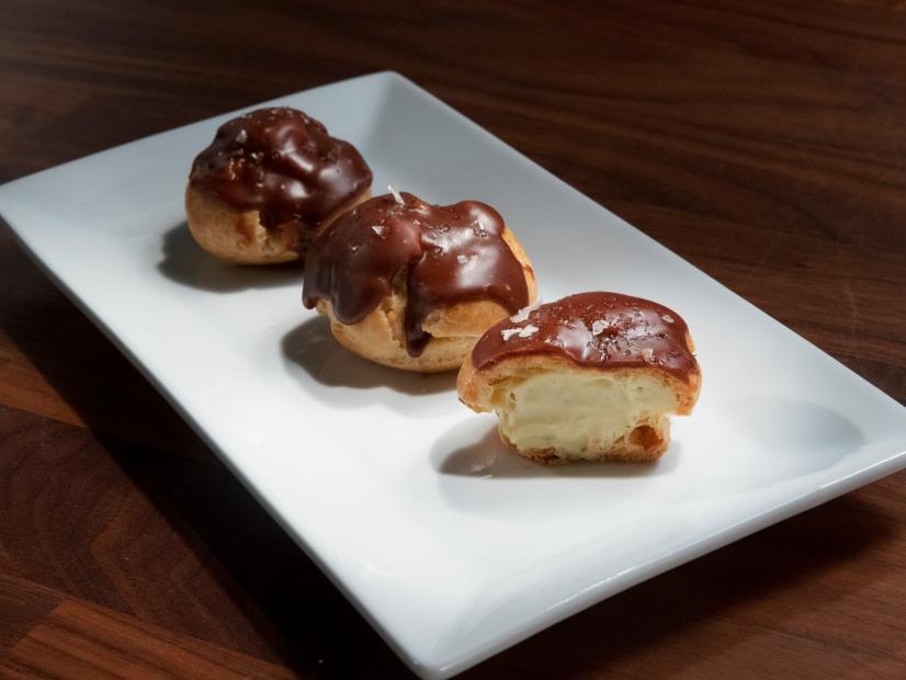 Jeff Mauro’s Profiteroles with Pistachio Pastry Cream and Chocolate Ganache are displayed, as seen on Worst Cooks in America, Season 26.