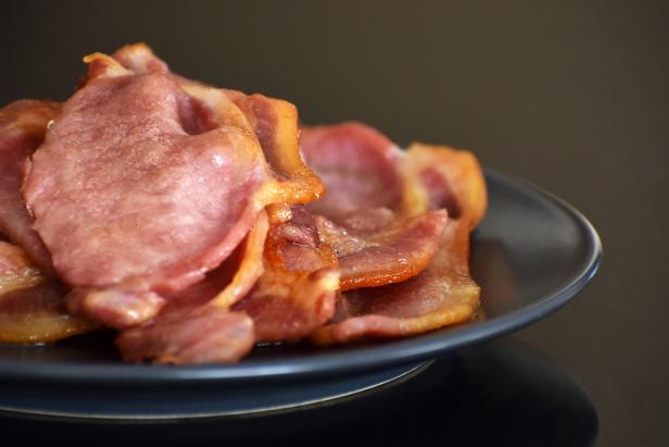 Back bacon on a blue plate. Selective focus.