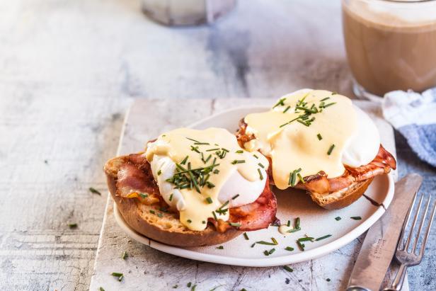 Traditional egg benedict with slices of bacon on toast,  poached egg and hollandaise