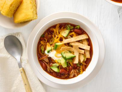 KANSAS CITY–STYLE PULLED PORK CHILI. Served with sour cream\, shredded cheddar cheese\, sliced scallions\, diced avocado\, tortilla strips and cornbread.