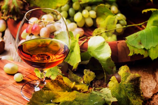 Cognac In Glass, Grapes And Vine, Vintage Wood Background, Selective Focus