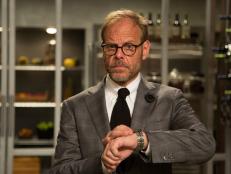 Host Alton Brown checks time during Round 1 cook, as seen on Food Network's Cutthroat Kitchen, Season 5.