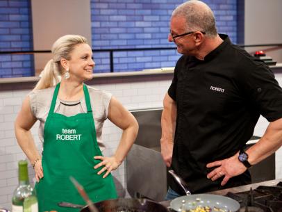 Cook Natasha Clement and mentor Robert Irvine smile with relief after cooking their final dish, Gulf Shrimp and Red Snapper, as seen on Food Network's All-Star Academy, Season 2.
