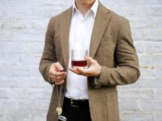 Elegant man holding glass of whiskey