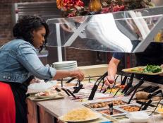 Contestants Jamika Pessoa and Matthew Grunwald gathering ingredients from the salad bar for the Mentor Challenge Passing the Bar, as seen on Food Network's Comeback Kitchen, Season 2.
