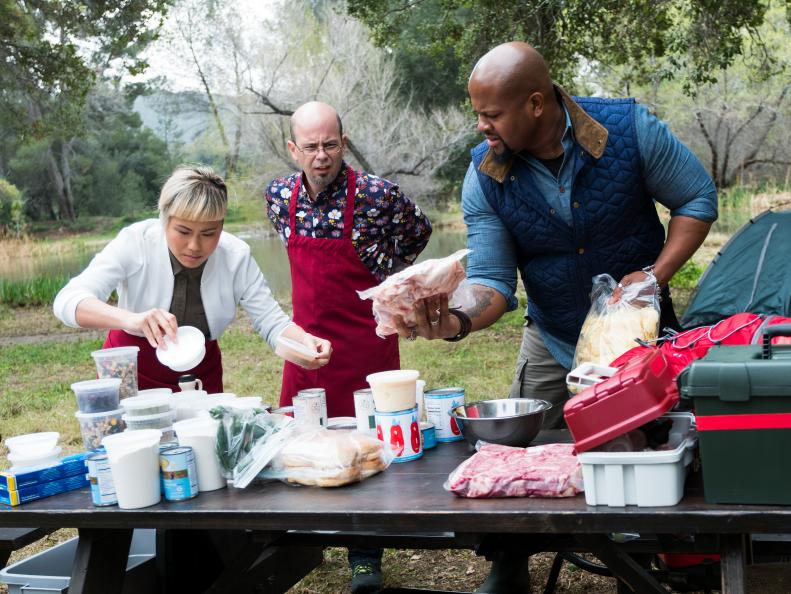 Contestants Coadan Tran, Jason Smith and David Rose sorting through their ingredients for the Star Challenge Camping to Glamping, as seen on Food Network Star, Season 13.