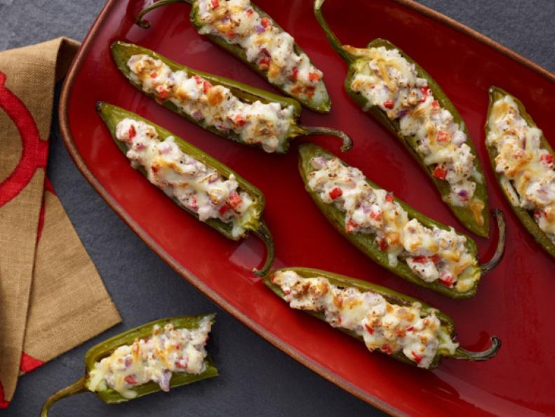 Italian stuffed jalapenos served on a red platter.