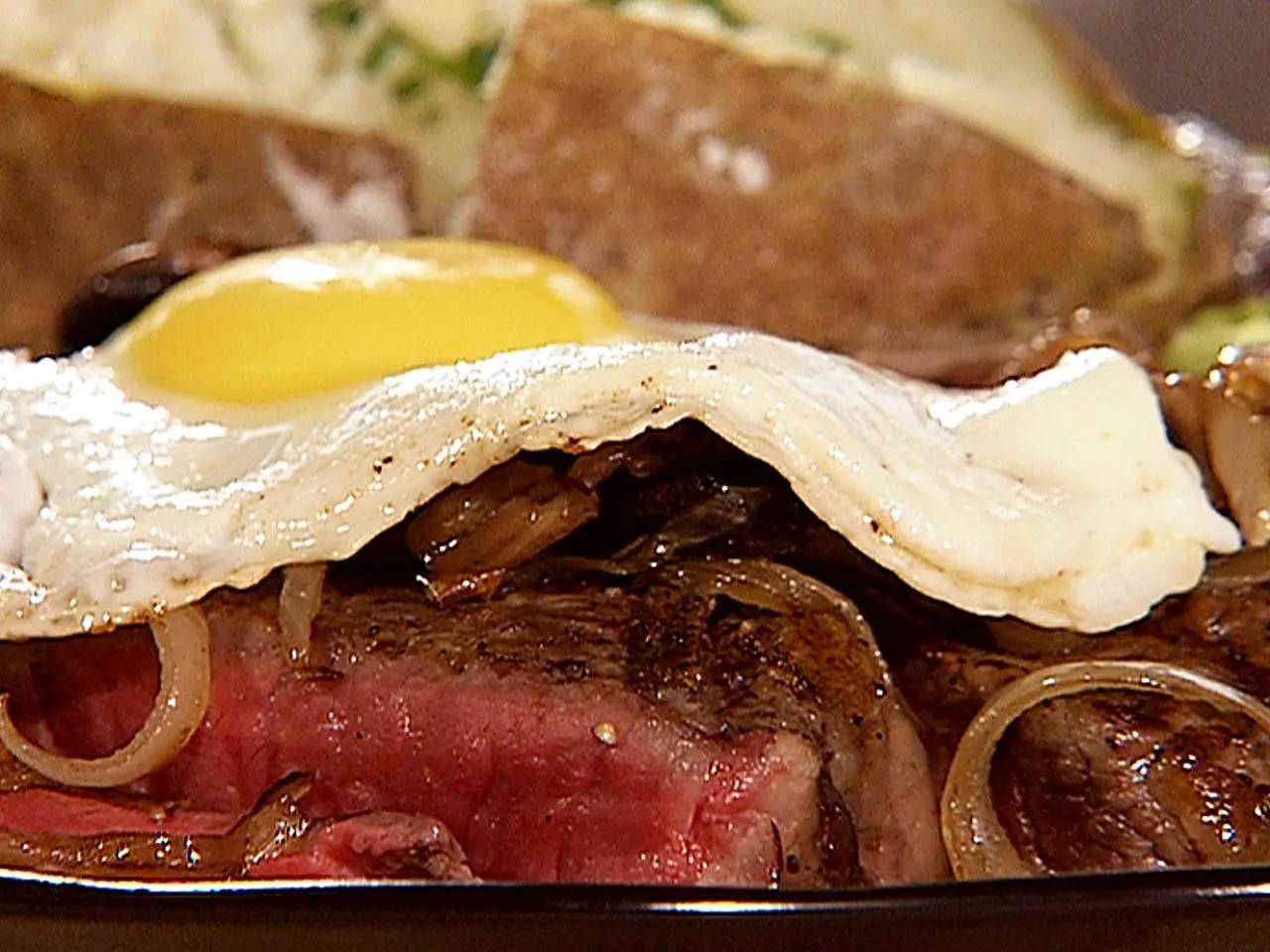 Beer Marinated T Bone Steak Sauteed Onions and Mushrooms Topped with a Fried Egg