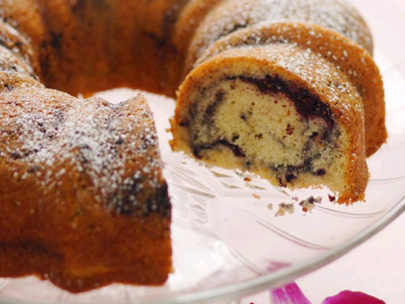 A Dark Cherry Bundt Cake Sprinkled With Powdered Sugar and Placed on a Glass Pedestal