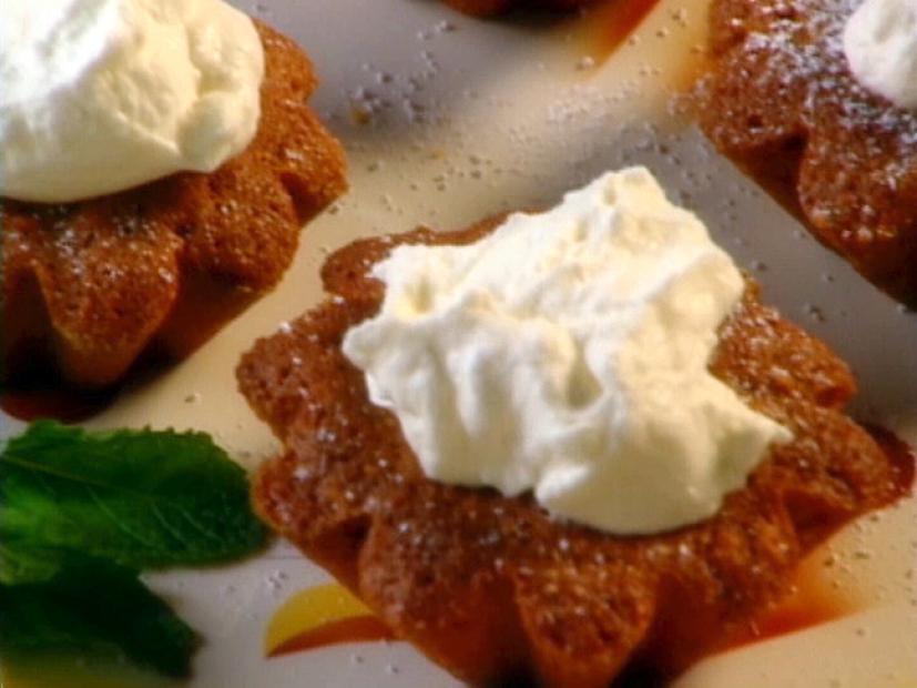 Polish Honey Cakes Which are Sprinkled With Sugar and Topped With Whipped Topping and are Adjacent to each other on a White, Orange and Yellow Plate