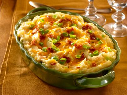 Creamy Loaded Mashed Potatoes Topped With Cheese, Bacon and Chives on a Gold Table Runner