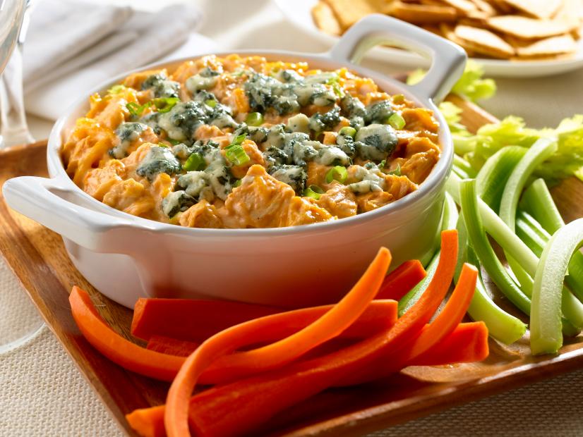 Disappearing Buffalo Chicken Dip in a Plain White Serving Dish With Handles Surrounded by Carrots and Celery