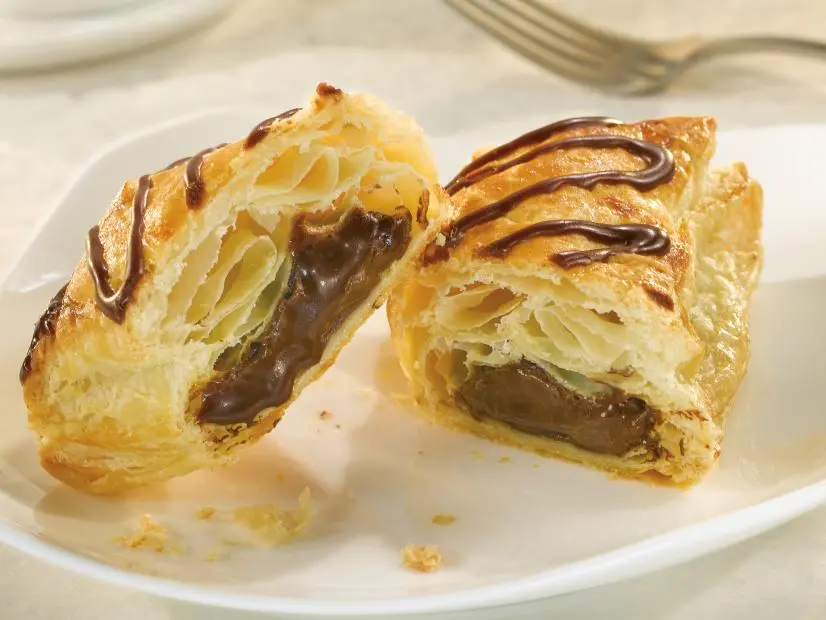 A Petit-au Pains au Chocolat cut in Half on a White Dish
