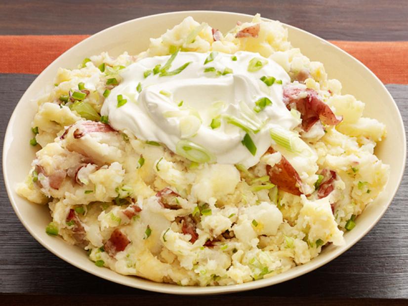 An Egg Shell Colored Dish with Sour Cream and Scallions atop Mashed Potatoes 