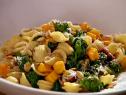 Closeup of Orecchiette with Pancetta Pumpkin and Broccoli Rabe Sprinkled with Cheese on a White Plate