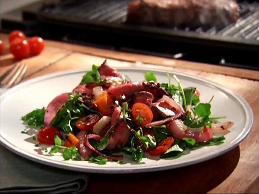 Sweet Pepper And Steak Salad on a Round Light Gray Plate on a Wooden Table Near a Grill