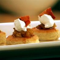 Puff Pastries Topped with Apples, Cream and Bacon on a White Dish