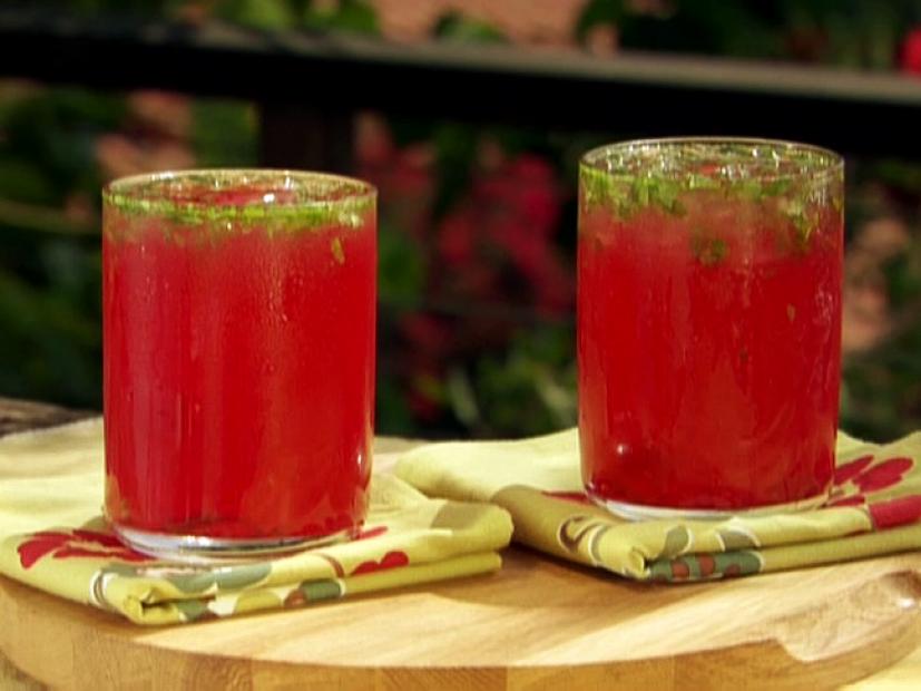 Two Glasses of Electric Blood Orange Limeade Garnished With Pieces of Mint Leaves