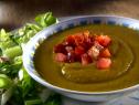 A Bowl of Split Pea Soup topped with diced tomatoes and bacon