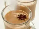 Two glass mugs of Chai Spice Toddy garnished with chocolate stars 