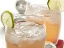 Two glasses of Cherry Splash with a cherry at the bottom of the glasses and garnished with a slice of lime
