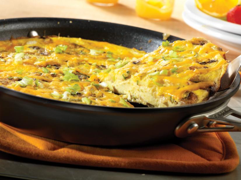 A Slice of Cheddar Broccoli Frittata being removed from a skillet with a spatula 