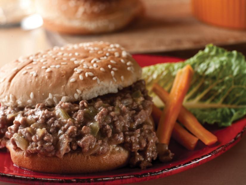 A Light Souper Burger on a red plate with carrot sticks and lettuce
