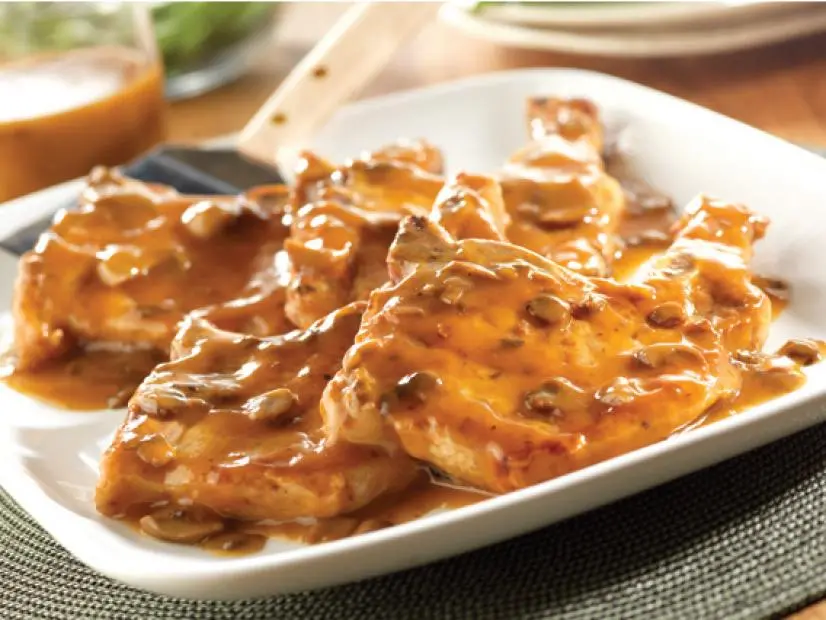 Pork Chops smothered in a mushroom sauce on a square white plate