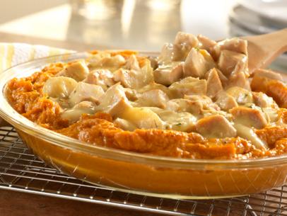 Turkey topping sweet potatos in an oval glass baking dish