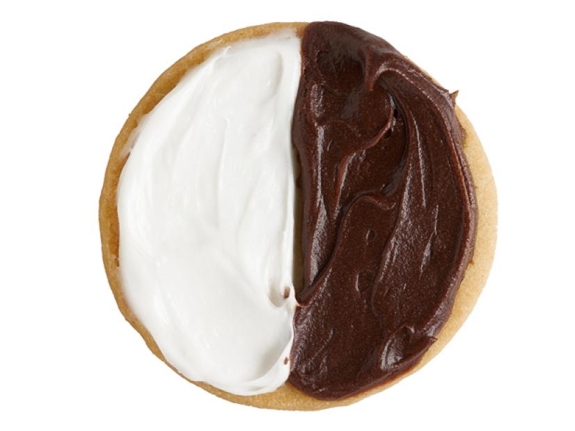 A cookie with half chocolate and half vanilla frosting on the top of it
