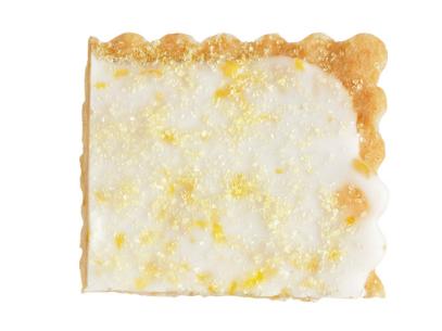 A portion of a lemon shortbread cookie with white frosting and sugar sprinkled on top