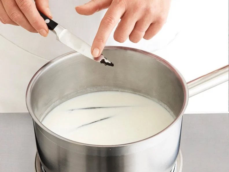Ingredients for Pastry Creme Being Brushed off a Knife into a Mixing Bowl