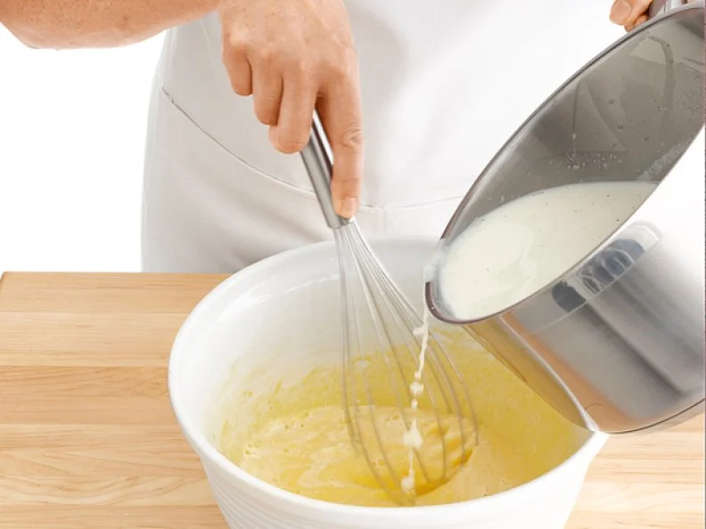 Pastry Creme Ingredients Being Poured and Mixed Into a Mixing Bowl
