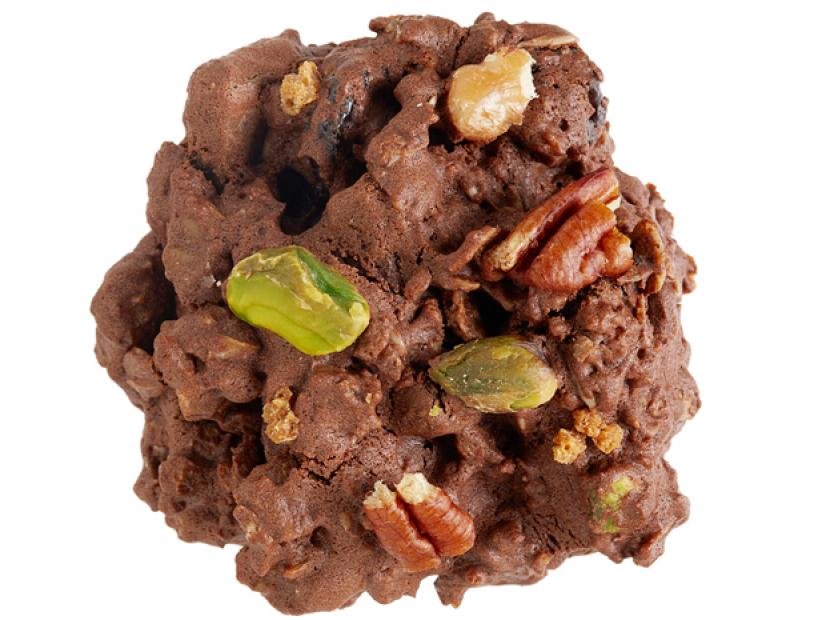 A Chocolate cookie full of various nuts placed against a white background