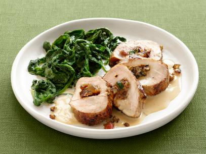 Slices of Stuffed Pork with Cooked Greens on a White Plate