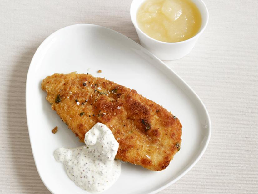 Chicken Schnitzel with a white sauce on a white gum drop shaped plate
