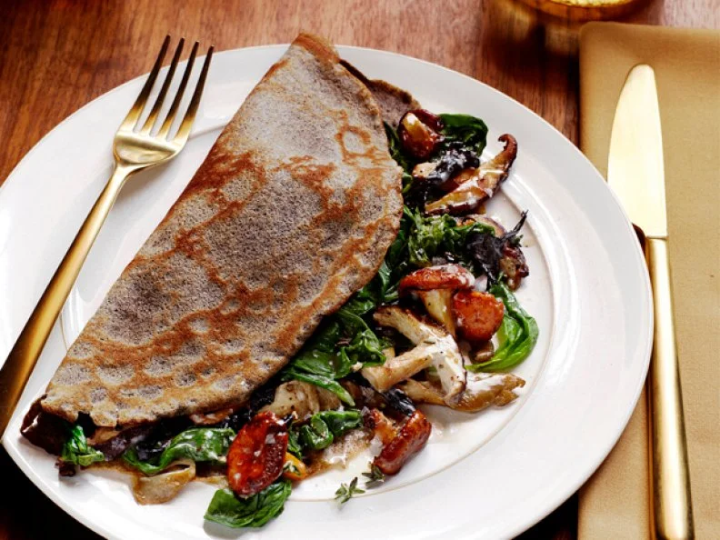 Crepe Party Main Crepe Stuffed with Spinach, and Mushrooms on a Plain White Plate