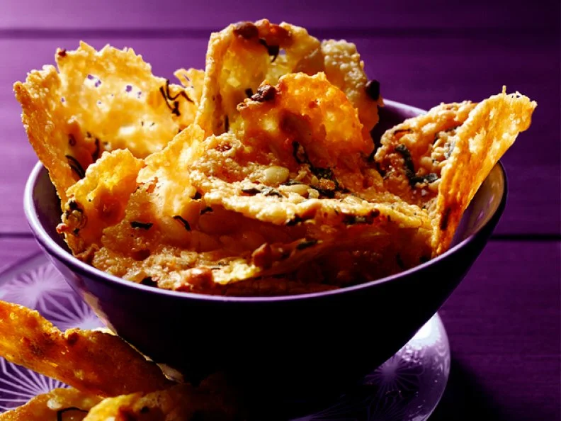 Frugal Party Main App Crispy chips as a main appetizer in a bowl against a purple background