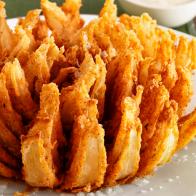 An Onion Bloom Sprinkled With Salt and Placed on a Round White Plate