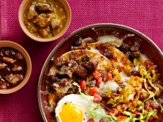 A Skillet Filled with a Mixture of Tortillas, Vegetables, Eggs and Meat on a Raspberry Colored Tablecloth